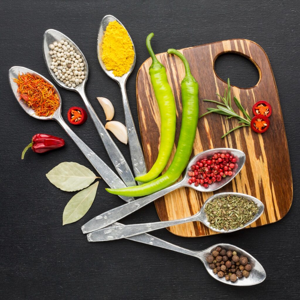 Spoons with powder seasoning on wooden board