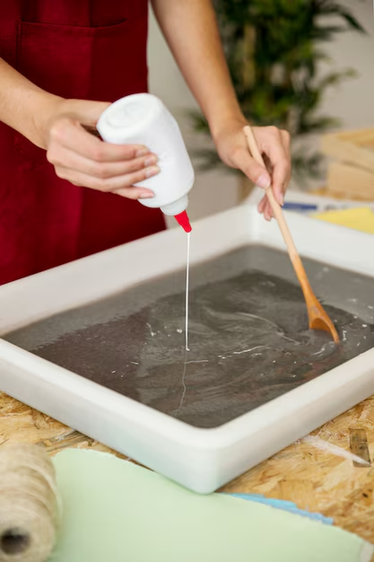close-up-woman-s-hand-pouring-glue-paper-pulp